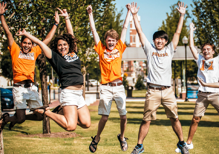 Five students jumping in the air
